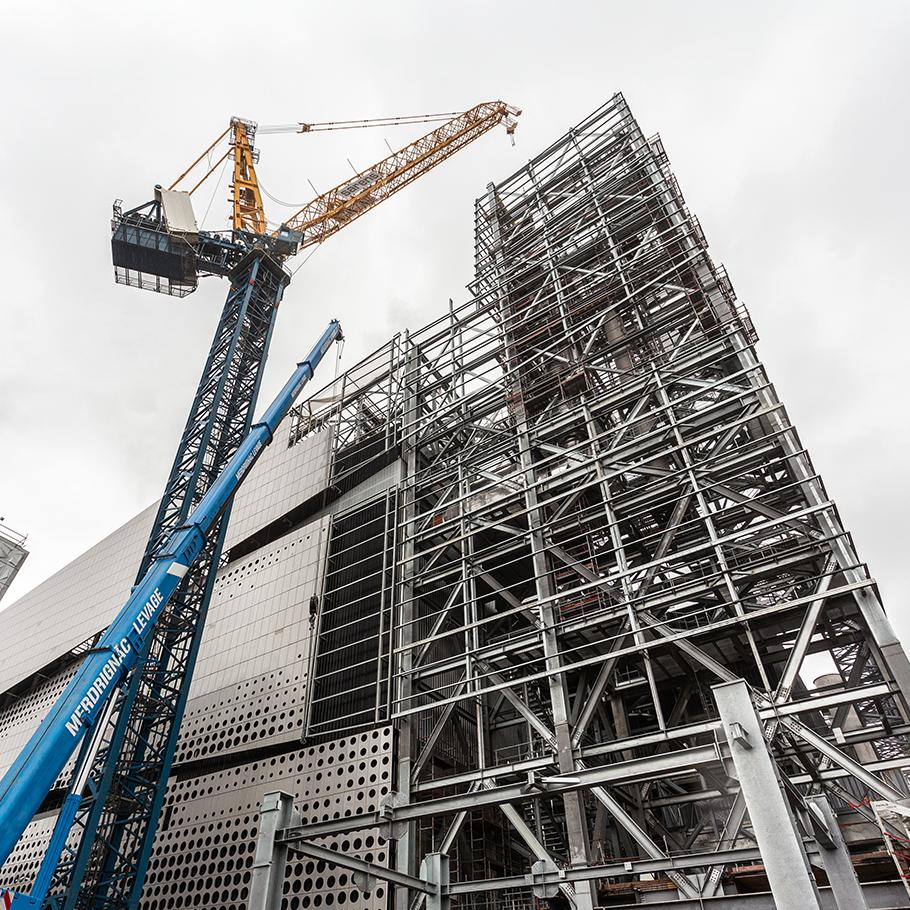 A crane standing beside a building under construction in the background.